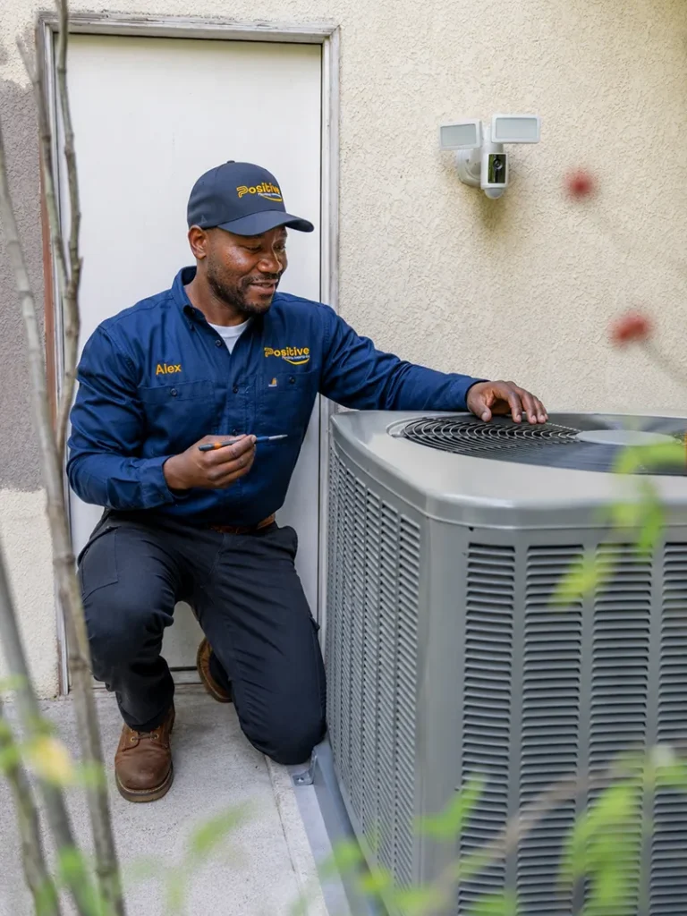 Irvine AC & HVAC After – New System Installation Positive Plumbing technician checking a newly installed outdoor AC system at an Irvine property